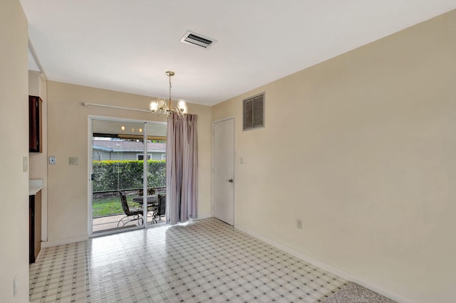 spare room featuring a chandelier, visible vents, and baseboards