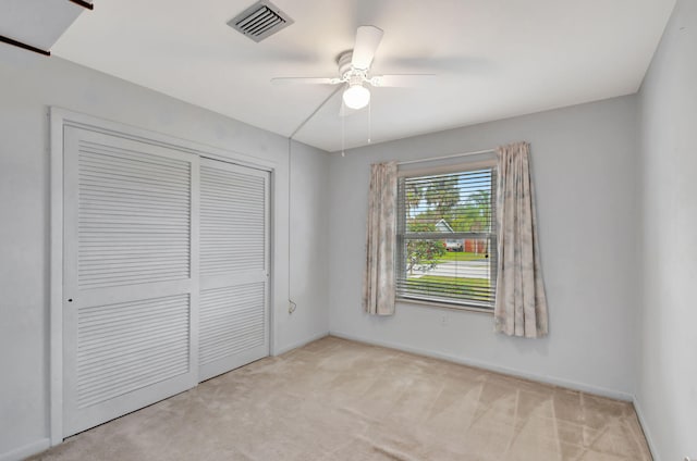 unfurnished bedroom with a closet, visible vents, carpet flooring, ceiling fan, and baseboards