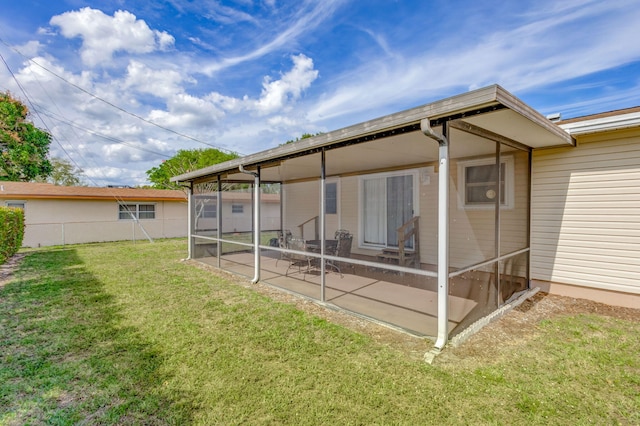 rear view of property with a sunroom and a lawn