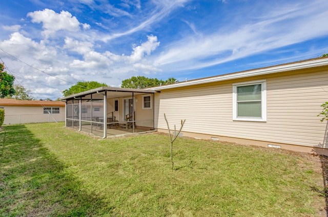 rear view of property featuring a sunroom, a yard, crawl space, and fence