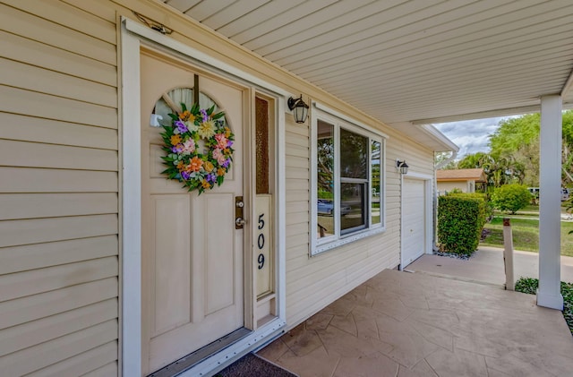 entrance to property featuring a porch and a garage