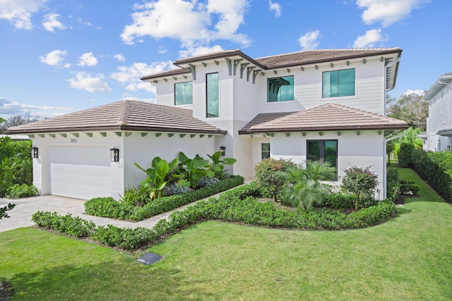 view of front of home with a garage and a front lawn