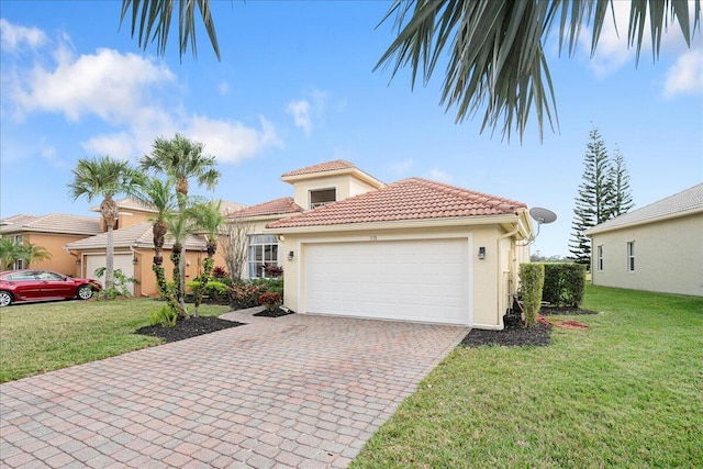 mediterranean / spanish house featuring stucco siding, a front yard, a tiled roof, and a garage