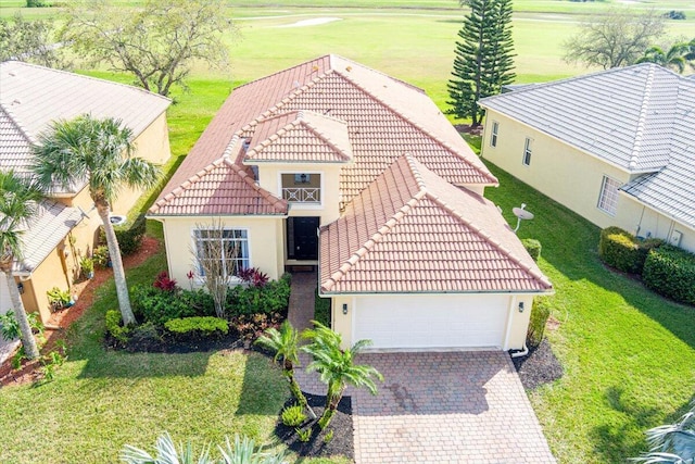 view of front facade featuring stucco siding, decorative driveway, and a tile roof