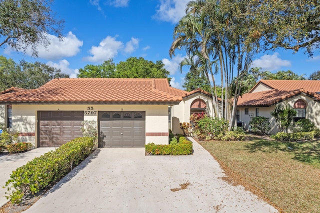 mediterranean / spanish home with a garage and a front lawn