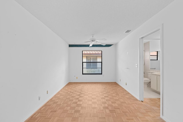 spare room featuring ceiling fan, a textured ceiling, and light parquet floors