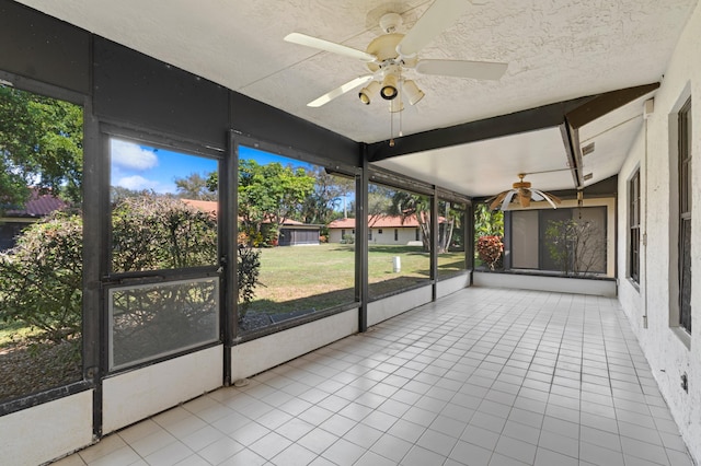 unfurnished sunroom featuring ceiling fan