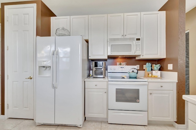 kitchen featuring light tile patterned flooring, white appliances, and white cabinets