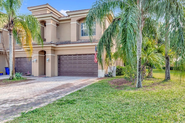 mediterranean / spanish home with a garage and a front lawn