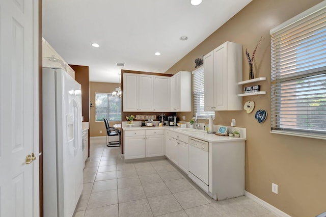 kitchen with sink, decorative light fixtures, light tile patterned floors, white appliances, and white cabinets