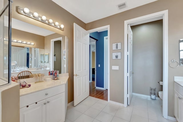 bathroom with vanity, tile patterned flooring, and toilet