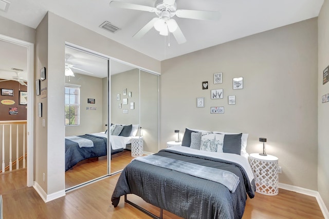 bedroom with wood-type flooring, a closet, and ceiling fan