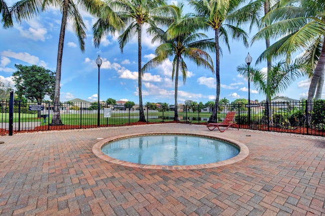 view of swimming pool with a hot tub