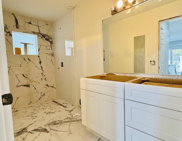 bathroom with tiled shower and vanity