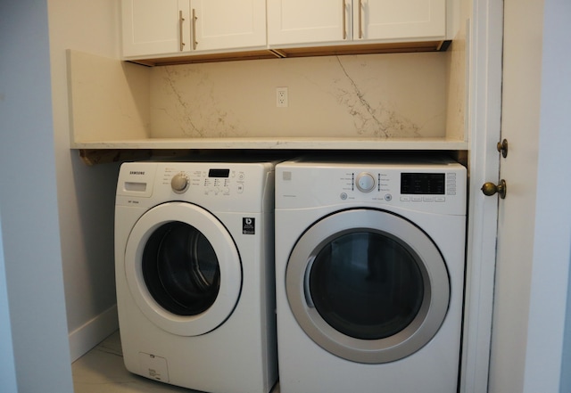 clothes washing area with cabinets and separate washer and dryer