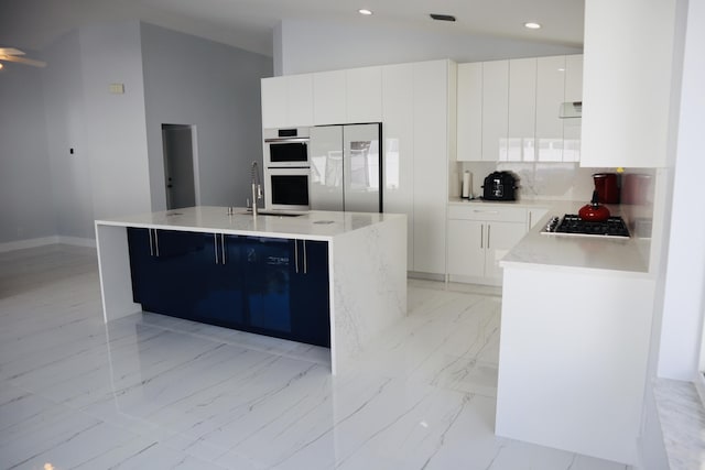 kitchen with sink, white cabinetry, backsplash, stainless steel appliances, and an island with sink