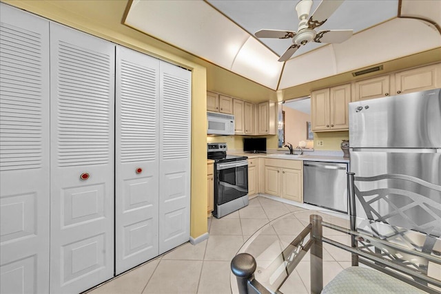 kitchen featuring light tile patterned floors, sink, ceiling fan, stainless steel appliances, and light brown cabinets