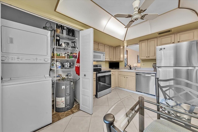 kitchen featuring stacked washing maching and dryer, appliances with stainless steel finishes, sink, light tile patterned floors, and electric water heater