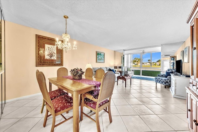 dining space with light tile patterned flooring, a wall of windows, a chandelier, and a textured ceiling