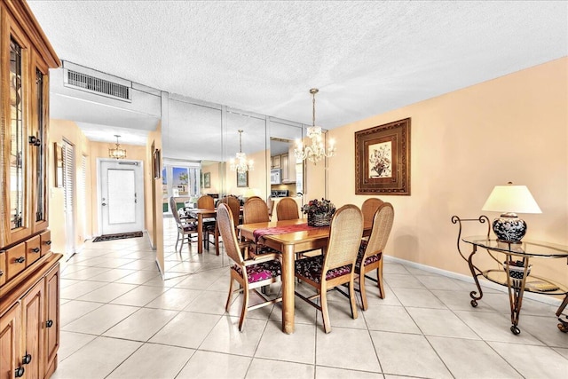 tiled dining space with a textured ceiling and a chandelier