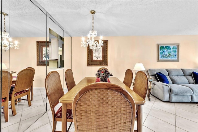 dining space with a chandelier, a textured ceiling, and light tile patterned floors