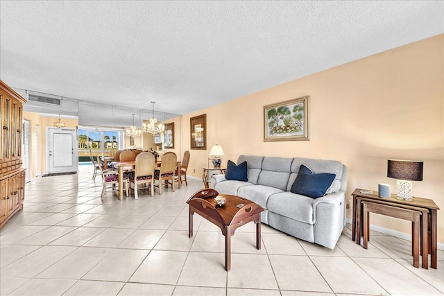 living room with a chandelier, a textured ceiling, and light tile patterned floors