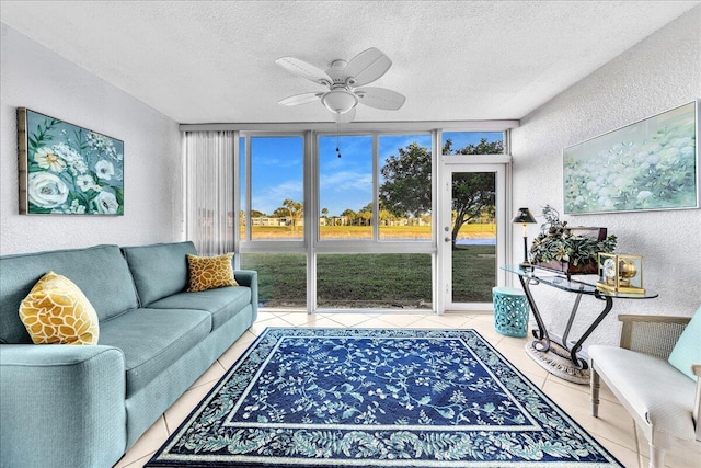 tiled living room with expansive windows, ceiling fan, and a textured ceiling