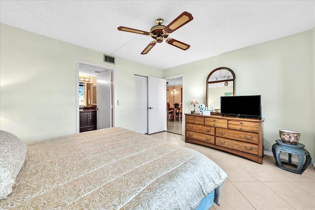 tiled bedroom featuring ceiling fan and ensuite bathroom