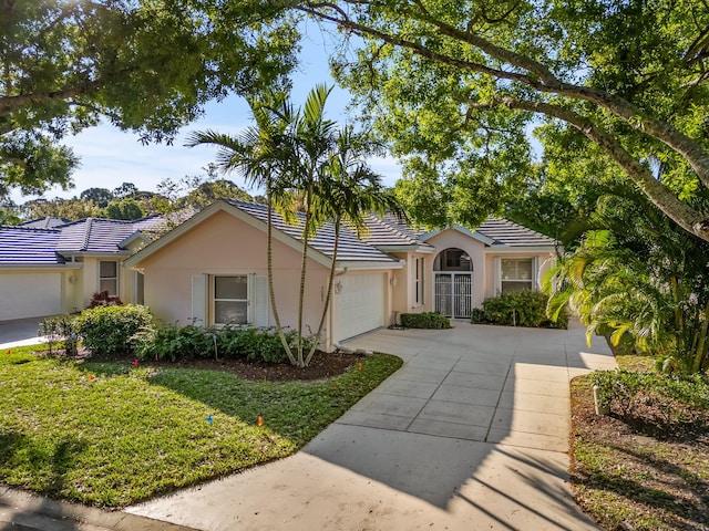 ranch-style house with a garage and a front yard