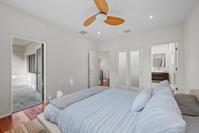 bedroom featuring ceiling fan, hardwood / wood-style floors, and ensuite bath