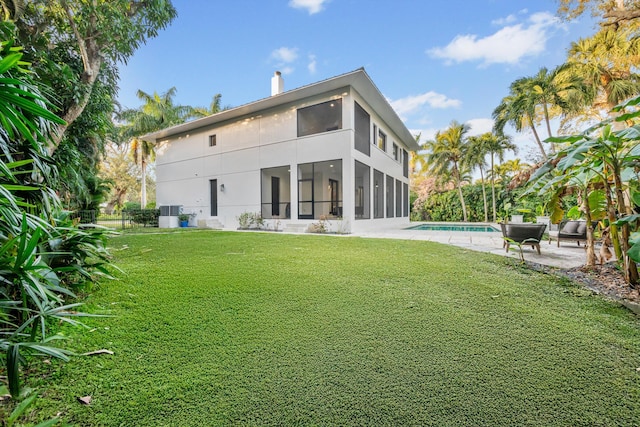 back of house with a patio area and a lawn