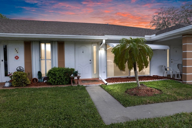 exterior entry at dusk with a lawn