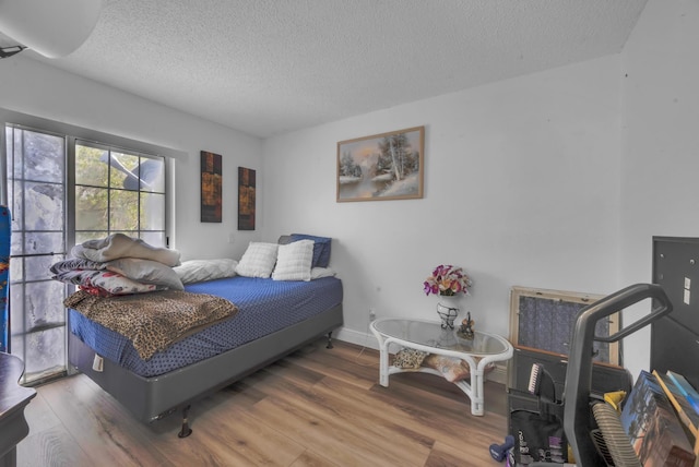 bedroom with wood-type flooring and a textured ceiling