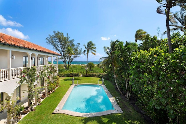 view of pool featuring a yard and a water view