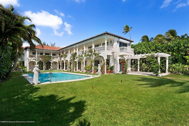 back of house with a balcony, a patio, a pergola, and a lawn