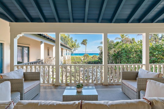 sunroom / solarium with beam ceiling and a water view