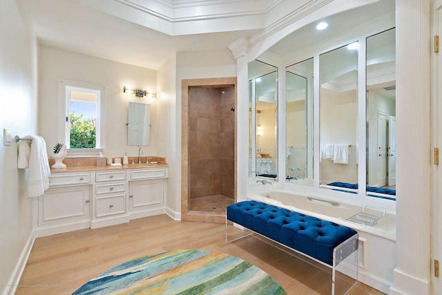 bathroom with tiled shower, vanity, and hardwood / wood-style floors