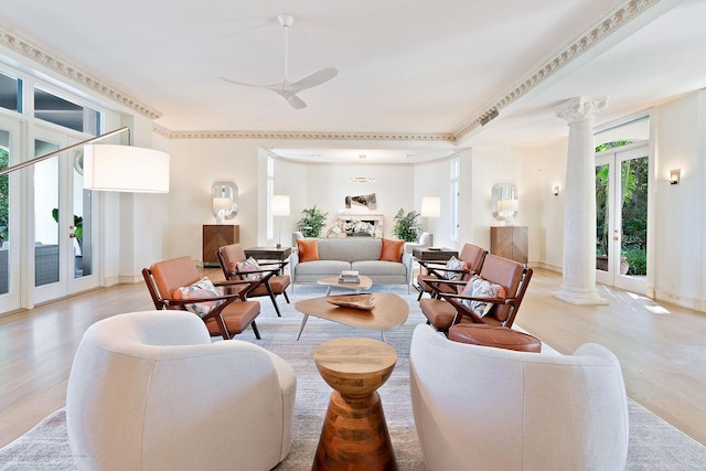 living room with ornate columns, light hardwood / wood-style flooring, ceiling fan, and french doors