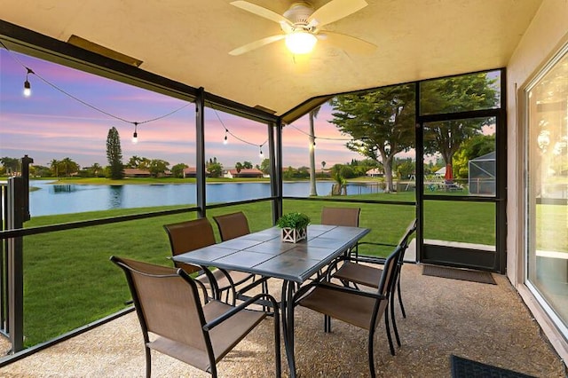 sunroom with a water view and ceiling fan