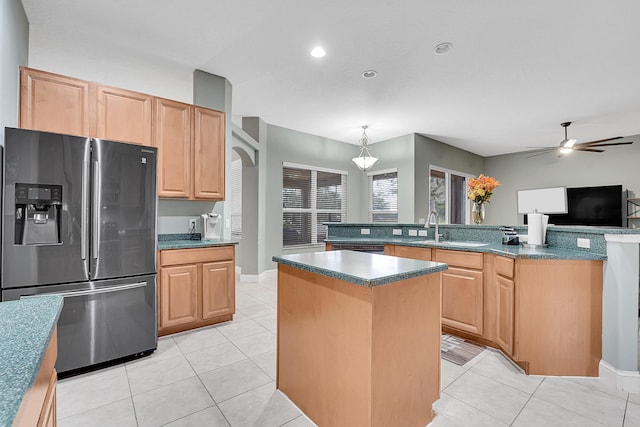 kitchen featuring light tile patterned floors, dark countertops, a kitchen island, light brown cabinets, and stainless steel refrigerator with ice dispenser