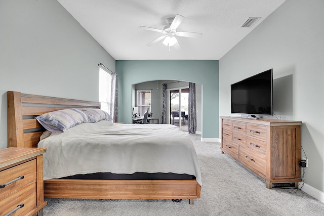 bedroom featuring light carpet, visible vents, arched walkways, and baseboards