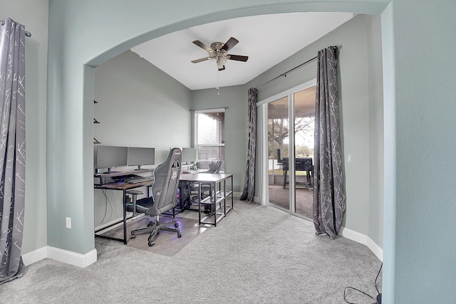 office featuring a ceiling fan, arched walkways, light carpet, and baseboards