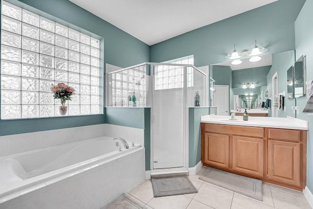 bathroom featuring a stall shower, a garden tub, vanity, and tile patterned floors