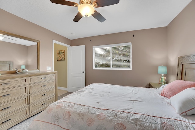 bedroom with light carpet, baseboards, and a ceiling fan