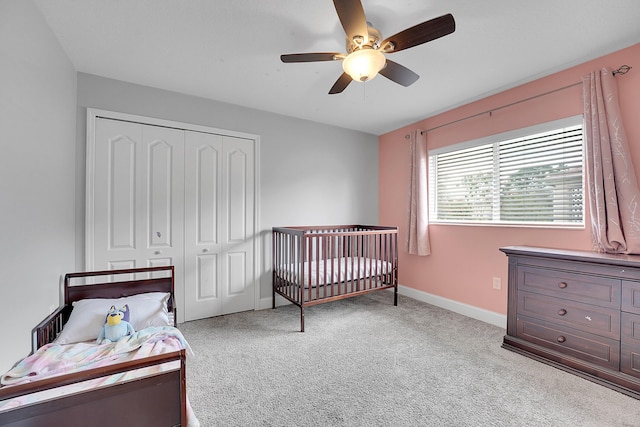 bedroom featuring light carpet, a closet, a ceiling fan, and baseboards