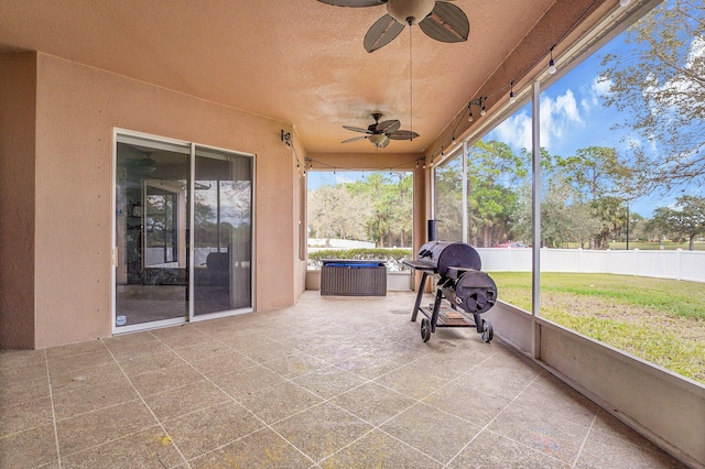 unfurnished sunroom with a ceiling fan