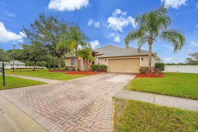 ranch-style home with a front lawn, decorative driveway, an attached garage, and stucco siding