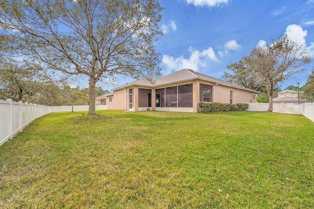 back of property with a lawn, a fenced backyard, a sunroom, and stucco siding