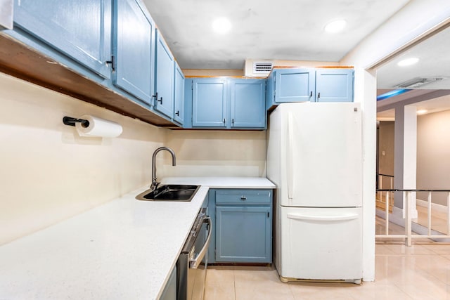 kitchen with blue cabinets, sink, light tile patterned floors, and white refrigerator