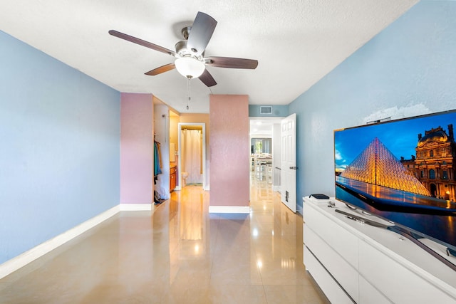 interior space with ceiling fan and a textured ceiling